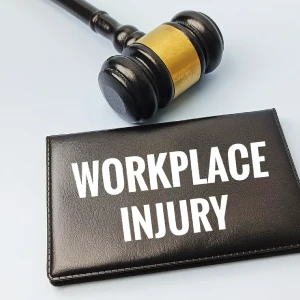 Gavel beside a notebook labeled workplace injury